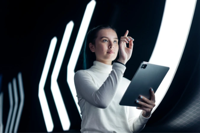 Profissional de tecnologia interagindo com interface digital futurista enquanto segura um tablet.