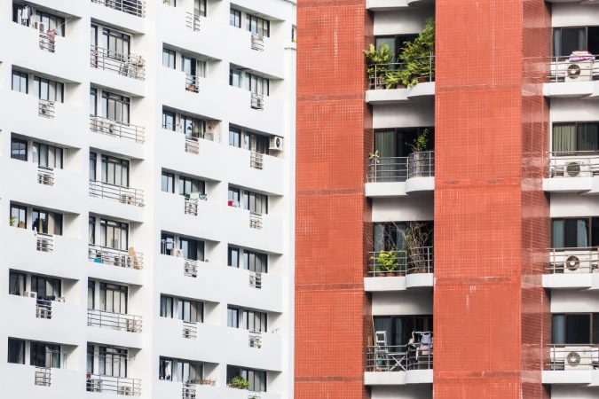 Dois edifícios com fachadas distintas e unidades residenciais otimizadas, lado a lado.