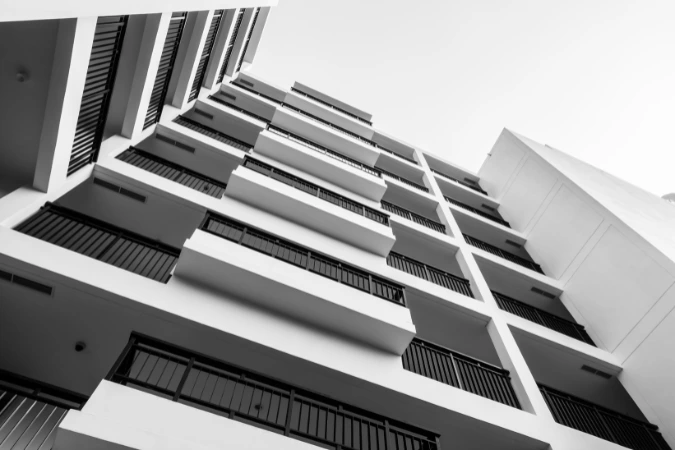 Perspectiva de edifício residencial compacto com sacadas lineares e estrutura enxuta.