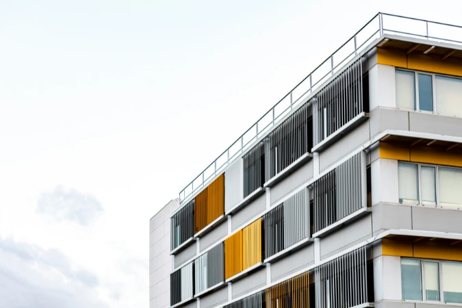 Fachada contemporânea de edifício compacto com painéis verticais coloridos.
