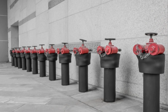 Série de hidrantes instalados na parede externa de edifício comercial