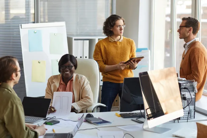 Equipe de projetos em reunião estratégica utilizando ferramenta de atendimento ao cliente integrada às tarefas.