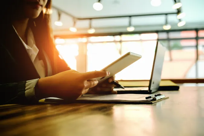 Profissional analisando tarefas em diferentes dispositivos com foco em produtividade ágil.