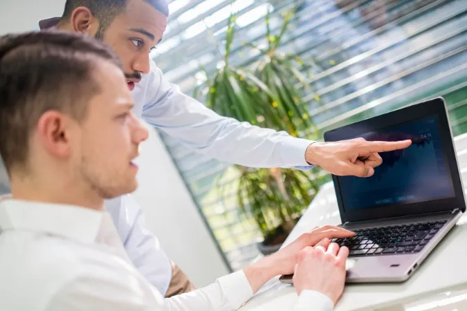 Dois profissionais analisando dados de CRM e projetos integrados em um notebook